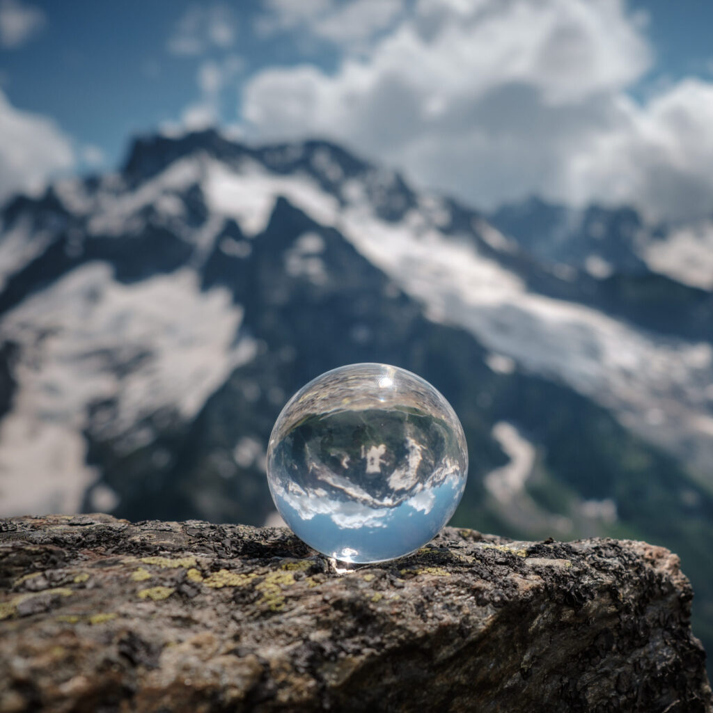 transparent glass sphere and snow capped peaks in the background