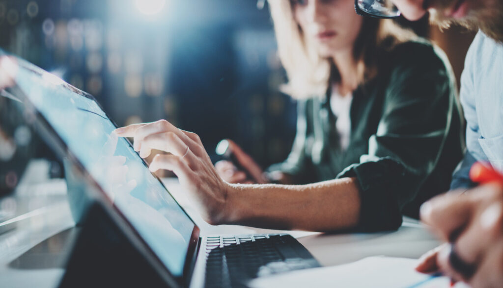woman pointing on digital tablet screen at night office .horizontal.blurred background.flares.
