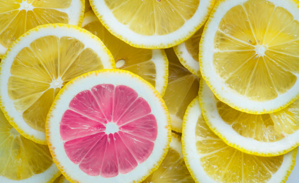 closeup of slices of lemon and one pink slice standing out textu